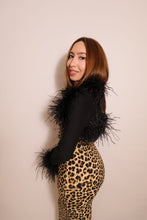 Model wearing a black long sleeve ostrich feather bolero with feather-trimmed shoulders and cuffs over a leopard print maxi dress