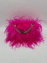 Hot pink ostrich feather handbag featuring fluffy feathers and a detachable silver chain handle.