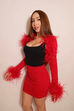 Angled view of a red ostrich feather bolero showcasing voluminous feather shoulder trim, fitted sleeves and dramatic feather cuffs.