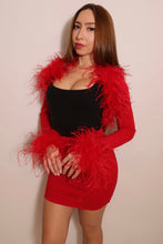 Model wearing a red ostrich feather bolero with long sleeves, dramatic feather shoulder trim and fluffy feather cuffs.